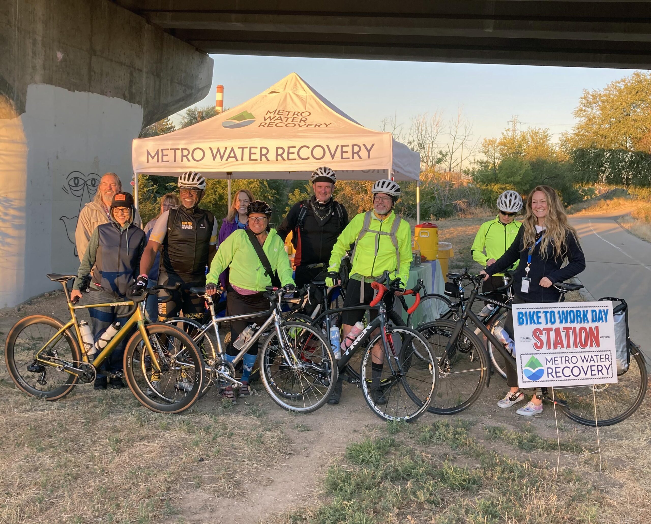 Our team of Metro volunteers standing in front of the Bike to Work Day support tent along the South Platte River