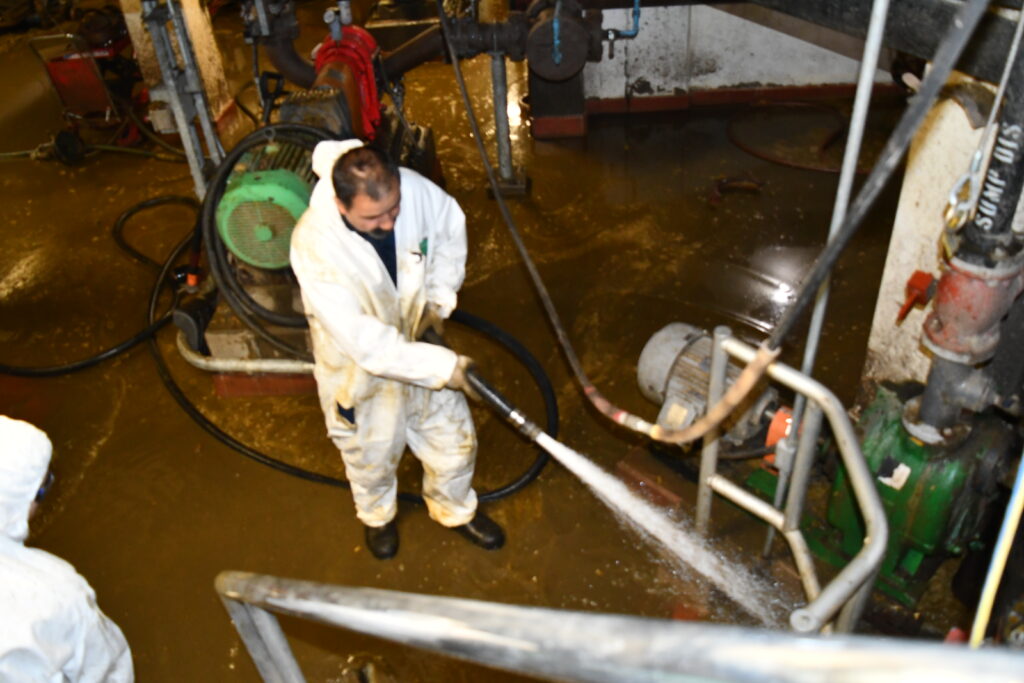 A worker spraying the floor