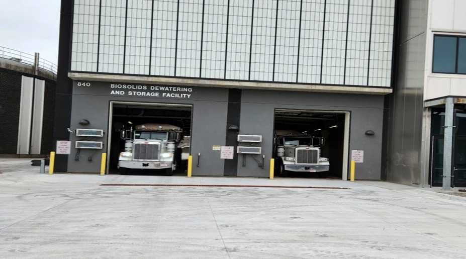 2 semi trucks sit in the bay of the biosolids building to be loaded simultaneously.