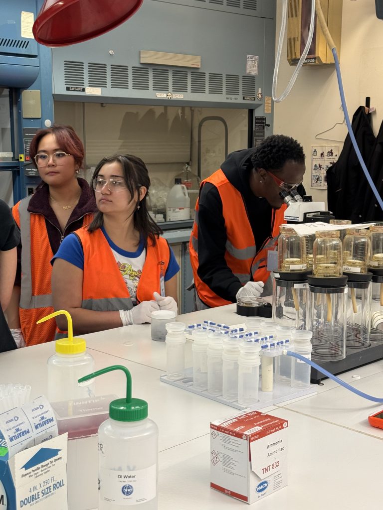 3 members of GRIT using lab equipment.
