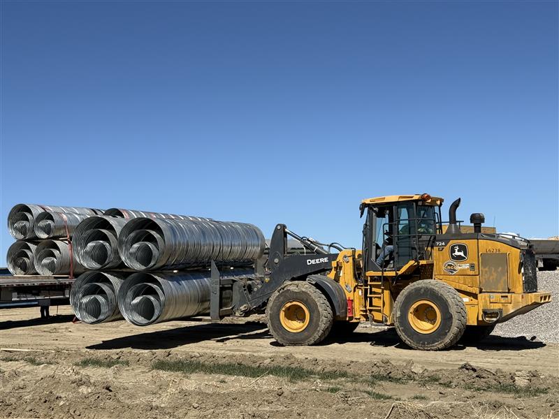 a forklift hauls culverts at the farm